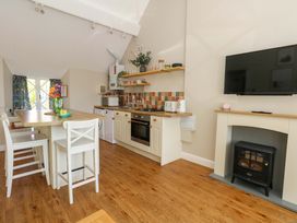 A kitchen with a dining table and appliances at Sea Pink Cottage in Langton Matravers