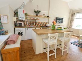 A kitchen with appliances and seating at Sea Pink Cottage in Langton Matravers