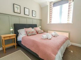 A bedroom with a bed and lamp at Sea Pink Cottage in Langton Matravers