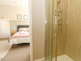 A bedroom with a bed and shower at Sea Pink Cottage in Langton Matravers