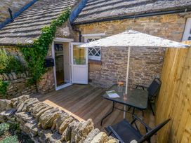A table and chairs under an umbrella at Sea Pink Cottage in Langton Matravers