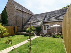 A garden with a building and pathway at Sea Pink Cottage in Langton Matravers