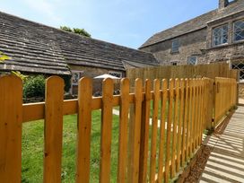 An outdoor area with a wooden fence and a building at Sea Pink Cottage in Langton Matravers