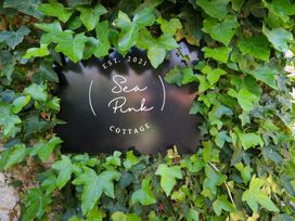 A sign for Sea Pink Cottage surrounded by ivy in Langton Matravers