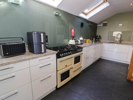 A kitchen with white cabinets a gas stove skylight and kitchen appliances at Fron Goch Farm in Llanfair Talhaiarn