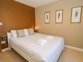 A bedroom with a white bed dressed with white linens and towels on the bed at Fron Goch Farm in Llanfair Talhaiarn