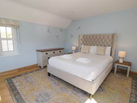 A bedroom with a bed a dresser bedside tables lamps and a window at Fron Goch Farm in Llanfair Talhaiarn