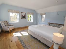 A bedroom with a bed and towels on it a carpet a chair and windows at Fron Goch Farm in Llanfair Talhaiarn