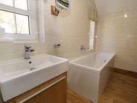 A bathroom with a sink and a bathtub near windows at Fron Goch Farm in Llanfair Talhaiarn