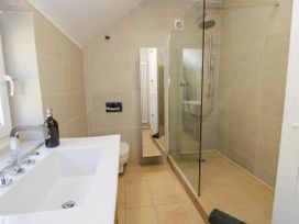 A bathroom with a sink a mirror a toilet and a glass walk in shower at Fron Goch Farm in Llanfair Talhaiarn