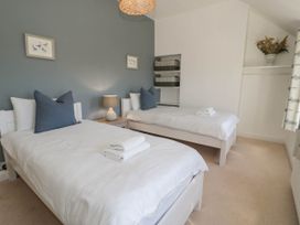 A bedroom with two single beds with white bedding and blue pillows at Fron Goch Farm in Llanfair Talhaiarn