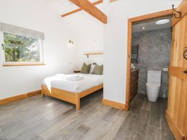 A bedroom with a bed and an attached bathroom at Fron Goch Farm in Llanfair Talhaiarn