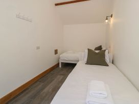 A bedroom with two single beds and folded towels at Fron Goch Farm in Llanfair Talhaiarn