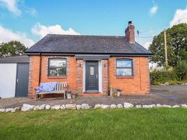 A cottage exterior with a door and bench at Bethania in Cefn Coch near Llanrhaeadr-Ym-Mochnant