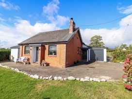 A house with a bench outside and a garage at Bethania in Cefn Coch near Llanrhaeadr-Ym-Mochnant