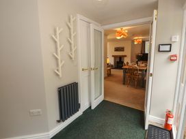 A hallway with coat racks and doors leading to another room at Swallow's Nest Thornthwaite near Braithwaite