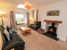A living room with a sofa and table at Swallow's Nest Thornthwaite near Braithwaite