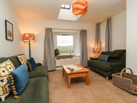 A living room with sofas and a table at Swallow's Nest Thornthwaite near Braithwaite