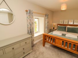 A bedroom with a bed and dresser at Swallow's Nest Thornthwaite near Braithwaite