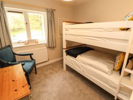 A bedroom with a bunk bed and desk at Swallow's Nest Thornthwaite near Braithwaite