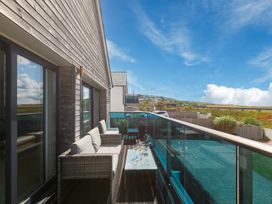 A balcony with a sofa and table at Sandbanks in Praa Sands