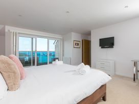 A bedroom with a bed and television at Sandbanks in Praa Sands