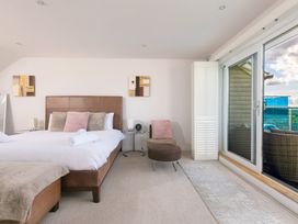 A bedroom with a bed and chair at Sandbanks in Praa Sands