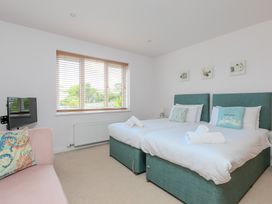 A bedroom with twin beds and a television at Sandbanks in Praa Sands