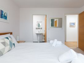A bedroom with a bed and wash basin at Sandbanks in Praa Sands