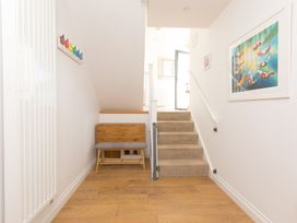 A hallway with a staircase and a bench at Sandbanks in Praa Sands