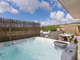 An outdoor area with a hot tub and table at Sandbanks in Praa Sands