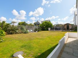 A garden with grass and furniture at Sandbanks in Praa Sands