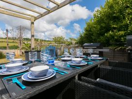 An outdoor dining area with table set for a meal at Sandbanks in Praa Sands
