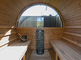 A sauna with wooden benches and an electric heater at Sandbanks in Praa Sands