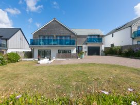 A house with a balcony and driveway at Sandbanks in Praa Sands