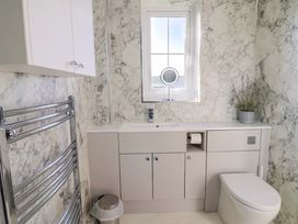 A bathroom with a sink and toilet at West Bay Holiday Home in West Bay