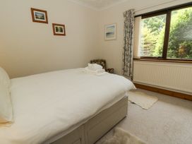 A bedroom with a bed and chair at Kala Spittal near Haverfordwest