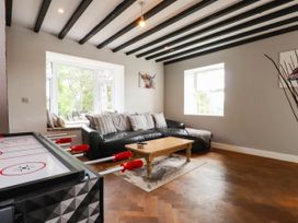 A living room with a sofa and air hockey table at Tyddyn Elidir near Old Colwyn