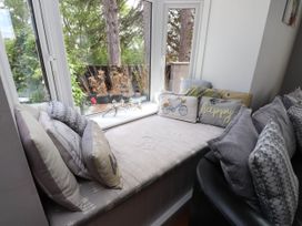 A window seat with cushions and potted plants at Tyddyn Elidir near Old Colwyn