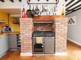 A kitchen with a stove and brick wall at Tyddyn Elidir near Old Colwyn