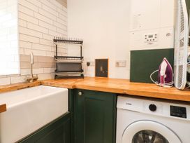 A laundry room with a sink and washing machine at Tyddyn Elidir near Old Colwyn