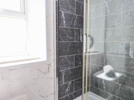 A bathroom with a shower and towel shelf at Tyddyn Elidir near Old Colwyn