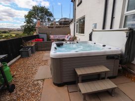 An outdoor space with a hot tub and seating area at Tyddyn Elidir near Old Colwyn