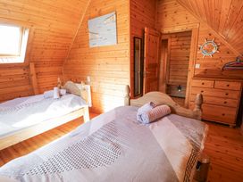 A bedroom with two wooden beds and towels on beds at Sun View Lodge in Llanbedr
