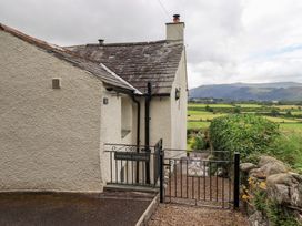 An outdoor view of Squirrel Cottage with garden and mountains in Bassenthwaite
