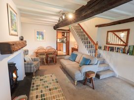 A living room with a sofa and dining area at Squirrel Cottage in Bassenthwaite