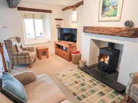 A living room with a television and fireplace at Squirrel Cottage in Bassenthwaite