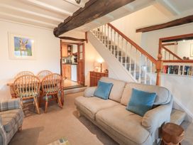 A living room with a sofa and dining table at Squirrel Cottage in Bassenthwaite