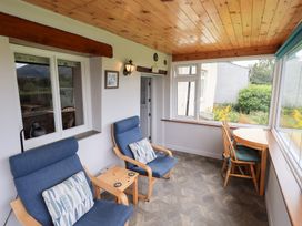A conservatory with seating and a table at Squirrel Cottage in Bassenthwaite