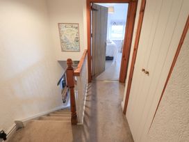 A hallway with stairs and a door to a room at Squirrel Cottage Bassenthwaite